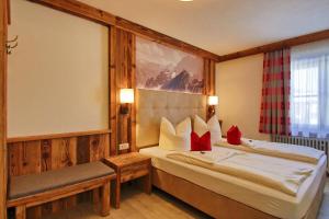 a hotel room with a bed with red pillows at Zeller Hof in Ruhpolding +87 photos