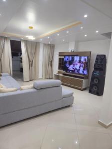 a living room with two couches and a flat screen tv at Apartamento aconchegante para temporada in Salvador
