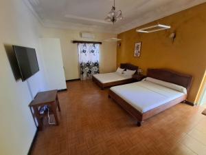 a room with two beds and a television in it at LOTUS HOTEL in Antsiranana