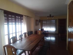 a dining room with a wooden table and chairs at Casa chalet neco in Necochea
