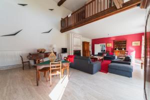 a living room with red walls and a table at La Maison de Thérèse, Longère 15 people in Bonneuil-Matours