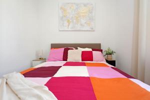 a bedroom with a bed with a colorful blanket at Centrale - ottimi collegamenti per Roma e APT in Fiumicino