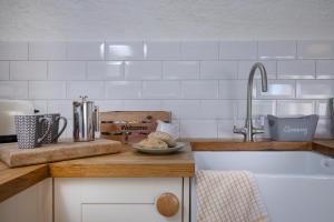 a kitchen with a sink and a counter top at Mill Cottage in Paignton +34 photos