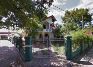 una valla verde frente a una casa en Tranquil Apt with Scenic Balcony, en Bopitiya