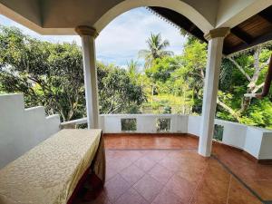 un porche de una casa con vistas al océano en Tranquil Apt with Scenic Balcony, en Bopitiya