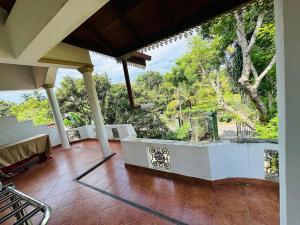 un porche de una casa con vistas al jardín en Tranquil Apt with Scenic Balcony, en Bopitiya 10 fotos más