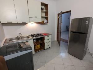 Una cocina con fregadero y frigorífico de acero inoxidable. en Tranquil Apt with Scenic Balcony, en Bopitiya
