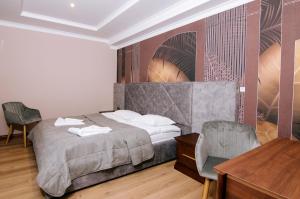 a bedroom with a bed and a table and chairs at Soprano Inn Hotel in Pasiky-Zubryts'ki