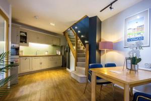 a kitchen and dining room with a staircase in a room at Swift Host - The Folly - 1 Bedroom - Courtyard Garden in Norwich