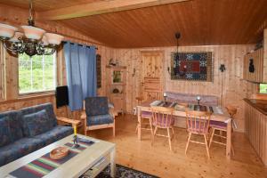 a living room with a couch and a table and chairs at Fjellhytten by Norgesbooking - cozy traditional cabin in Dalen