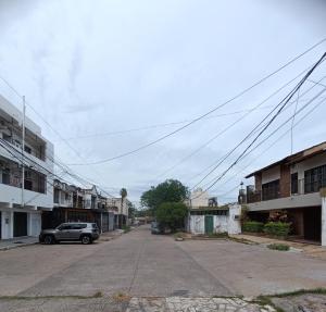 an empty street with a car parked on the road at PasajeHome in Resistencia