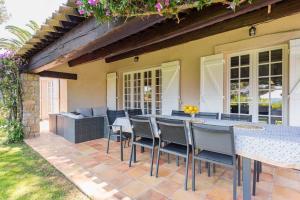 a patio with a table and chairs and a couch at Villa Le Patio à 20 m de la mer in Saint-Peïre-sur-Mer