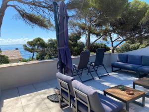 a patio with chairs and an umbrella and a table at Villa Le Patio à 20 m de la mer in Saint-Peïre-sur-Mer