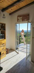 a woman standing outside a door in a kitchen at La Calusita Huerta Grande in Huerta Grande