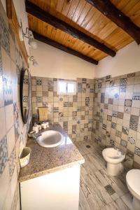 a bathroom with a sink and a toilet at La Calusita Huerta Grande in Huerta Grande +18 photos