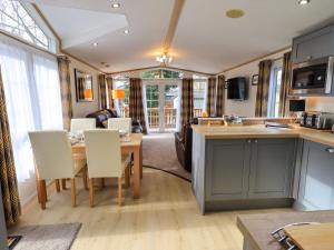 a kitchen and living room with a table and chairs at Squirrels Snug in Windermere
