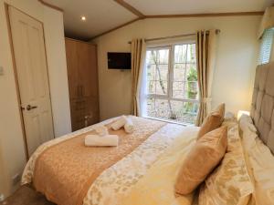 a bedroom with a bed with two towels on it at Squirrels Snug in Windermere