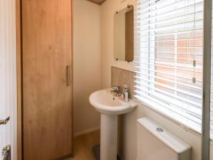 a white bathroom with a sink and a window at Squirrels Snug in Windermere +33 photos