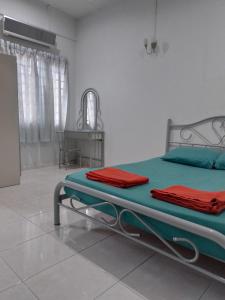 Batu EnamWelcome to Gemas Homestay ALI的一间卧室配有一张带绿色和红色床单的床