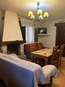 a living room with a table and a fireplace at Casa Rural Nelia in Villalba de la Sierra