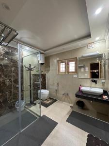 a bathroom with a shower and a sink and a toilet at Dream Stays in Nārachpur
