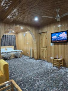 a room with a bed and a tv on a wall at Dream Stays in Nārachpur