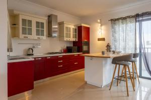 a kitchen with red and white cabinets and a counter at Penthouse Near Paceville with Private Terrace by QuickTrips in Is-Swieqi +24 photos