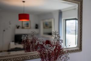 a mirror and a vase with flowers in front of it at Penthouse Near Paceville with Private Terrace by QuickTrips in Is-Swieqi