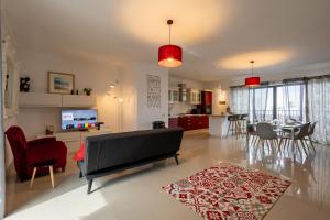 a living room with a couch and a dining room at Penthouse Near Paceville with Private Terrace by QuickTrips in Is-Swieqi