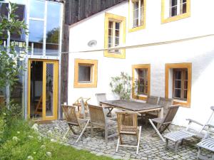 a patio with a wooden table and chairs at Einzeldenkmal in der Altstadt von Regensburg in Regensburg