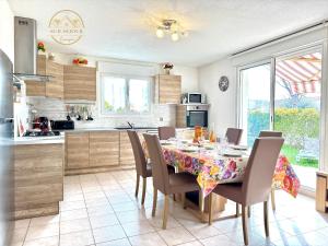 a kitchen with a dining room table and chairs at Villa Les Lauriers -3 Chambres, Climatisation, Terrasse, Jardin, BBQ & Plancha- SUDSEJOURCONCIERGERIE in Elne