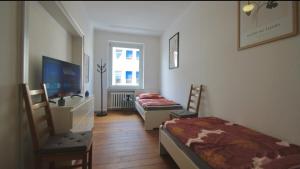 two beds in a room with a tv and a tv at City Apartment GL10 in Bergisch Gladbach