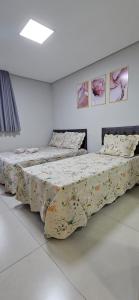 two beds in a room with paintings on the wall at Hotel Real in Ouro Preto +25 photos