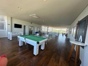 a large room with a pool table in it at casa arejada em condomínio na praia de atlântida in Xangri-lá