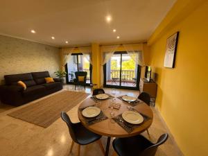 a living room with a wooden table and chairs at Javea Port Penthouse in Jávea