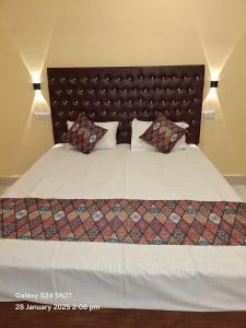 a bedroom with a large bed with white sheets and pillows at Hotel Grand Arya in Hilsa