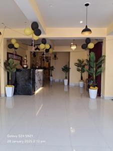 a large hall with potted plants and a lobby at Hotel Grand Arya in Hilsa +9 photos