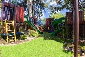 a playground with a slide in the grass at Afrique Boutique Hotel O.R. Tambo in Boksburg
