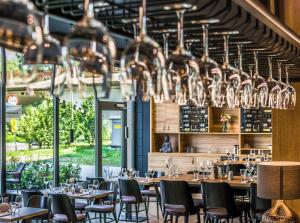 a dining room with tables and chairs and chandeliers at River Side Residence in Oświęcim