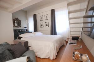 a bedroom with a white bed and a couch at Bargello Nine Luxury Suite in Florence