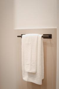 a white towel hanging on a towel rack in a bathroom at Bargello Nine Luxury Suite in Florence