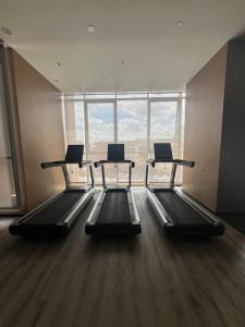 a gym with three treadmills in front of a large window at Skytrees 公寓 距Aeon五分钟路程 in Johor Bahru