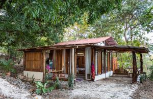 a small cabin in the woods with a table and chairs at Helenors estancia in Nicoya