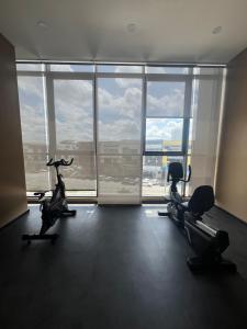 an empty gym with cardio machines in front of a large window at Skytrees 公寓 距Aeon五分钟路程 in Johor Bahru