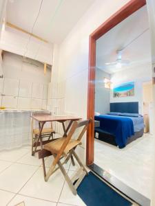 a room with a table and a bedroom at Suíte Pé na Areia in Arraial do Cabo