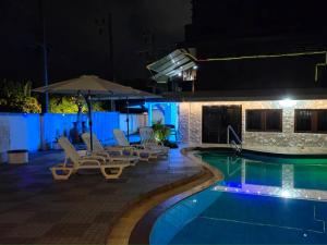 una piscina notturna con sedie e ombrellone di Baan Nur Nur 201 a Ban Lum Fuang
