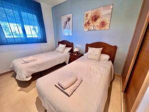 a room with two beds and a window at Condado De Alhama, Jardin 10 SV54 in Alhama de Murcia +6 photos