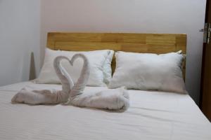 two swans towels sitting on a bed with pillows at Blue water Villa in Weligama