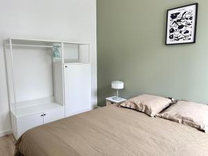 a bedroom with a bed and a white cabinet at Les Remparts, centre-ville d'Hennebont in Hennebont +4 photos
