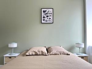 a bedroom with a bed with two lamps on two tables at Les Remparts, centre-ville d'Hennebont in Hennebont
